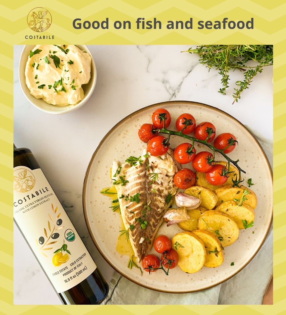 Lemon olive oil used as finishing oil on steamed fish with cherry tomatoes and baked potatoes - Costabile Olive Oil from Puglia Italy