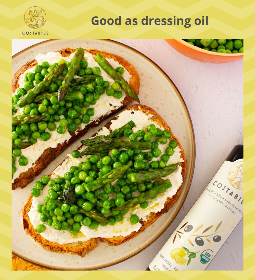 Lemon olive oil used as finishing oil on toasts with whipped feta cheese, asparagus, peas - Costabile Olive Oil from Puglia Italy